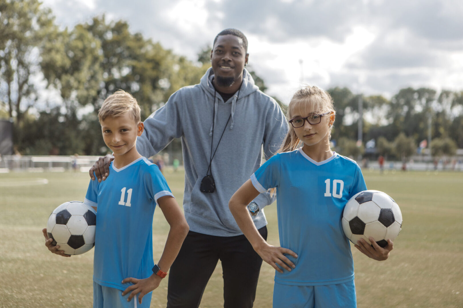 Coach with young soccer players on field.